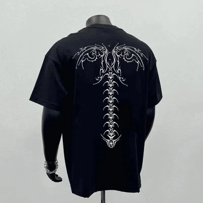 A man modelling a loose-fit black cotton short-sleeved shirt with a printed design.