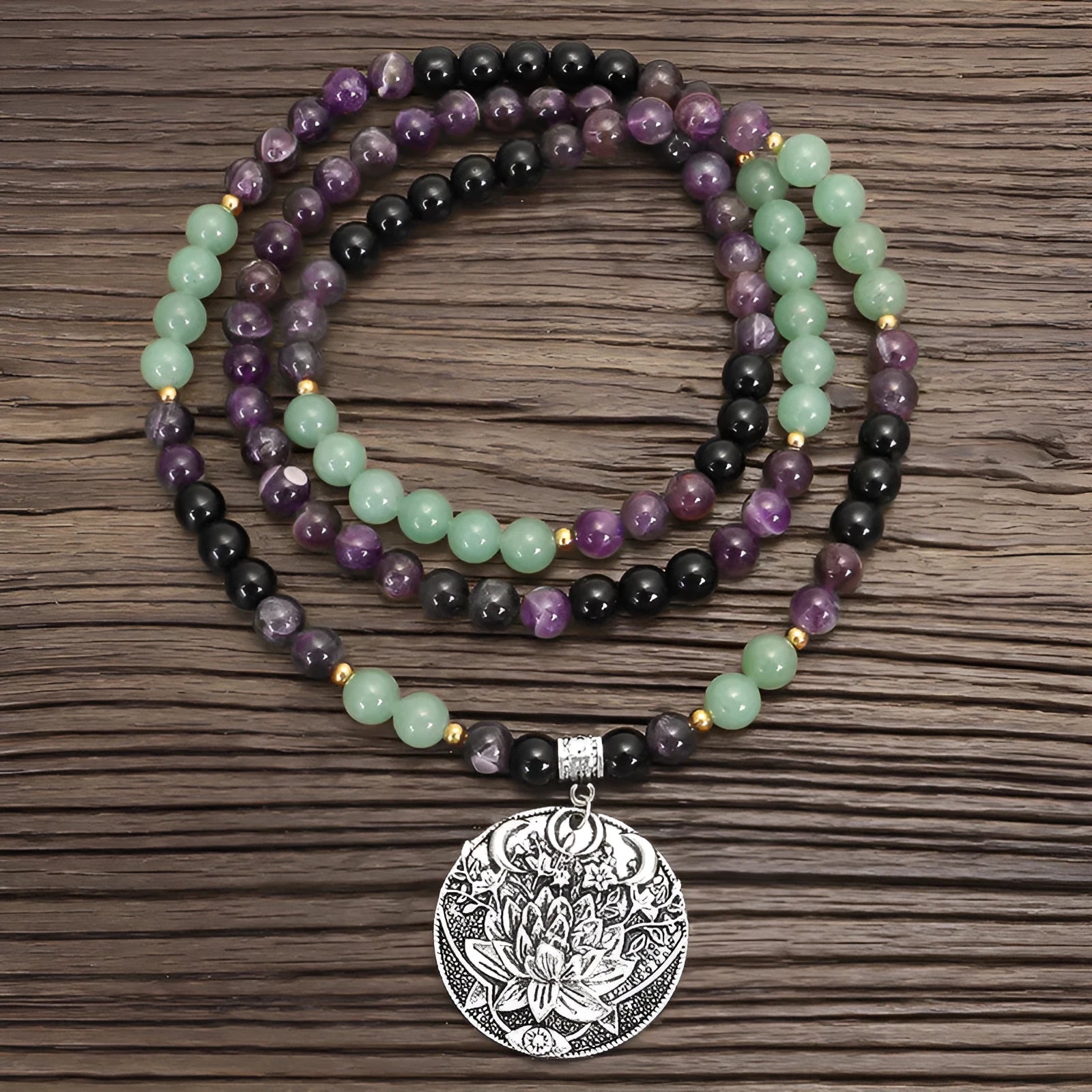 Yoga lotus pendant necklace and bracelet set with stone beads on a white background