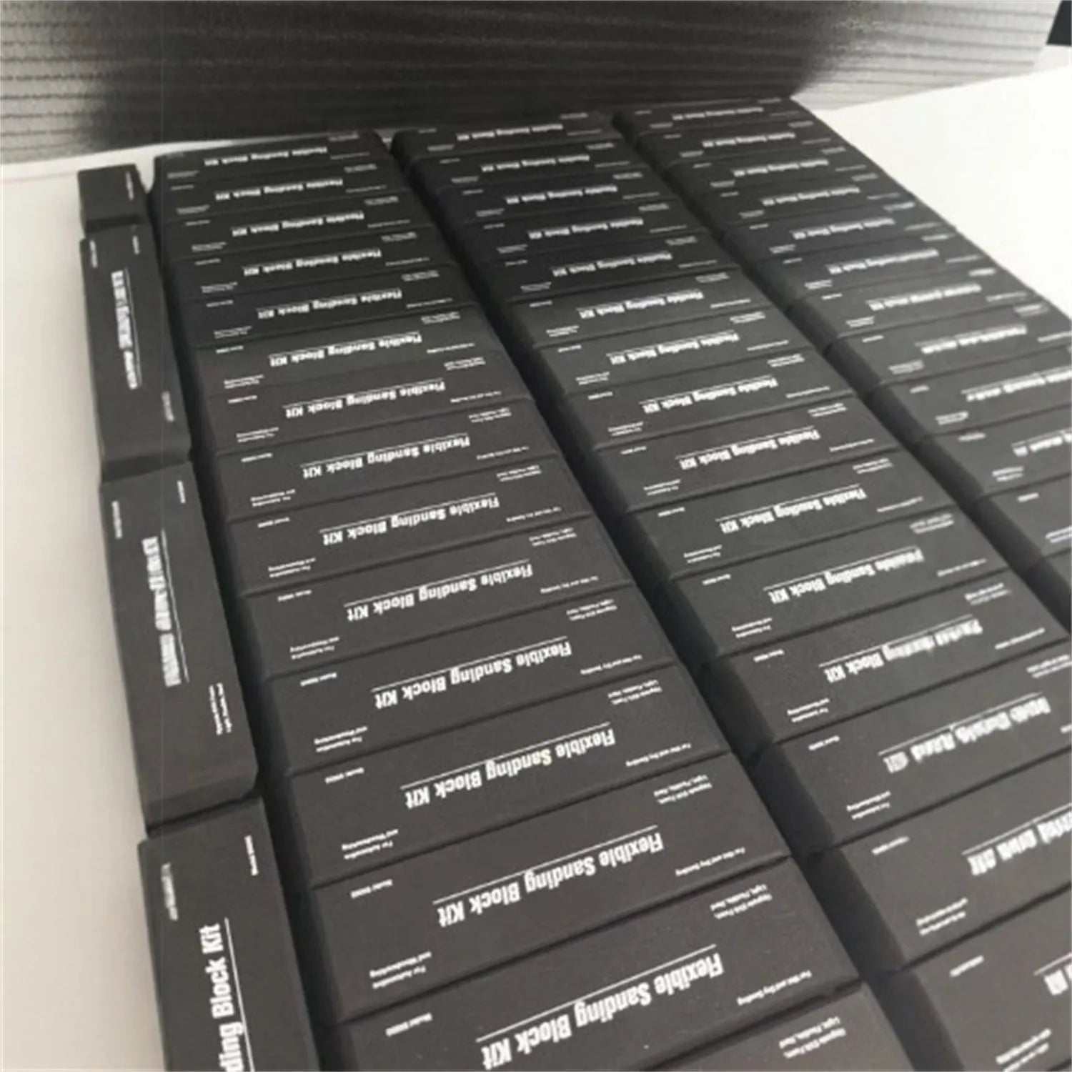Seven black frosted metal building blocks arranged for architectural model assembly