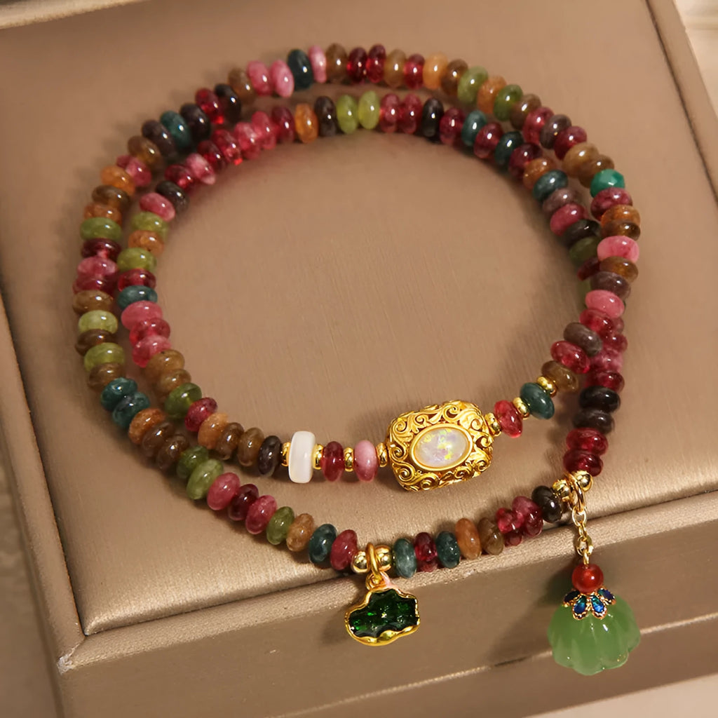 Rainbow tourmaline abacus beads double ring bracelet with lotus seedpod and flower shapes, on white background
