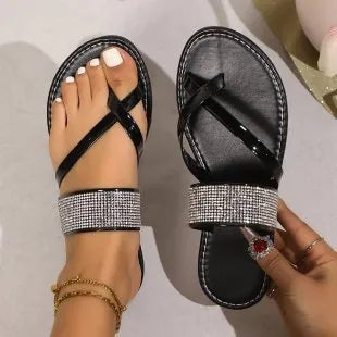 Women's flat beach sandals with a rhinestone-covered toe strap on a rubber sole.