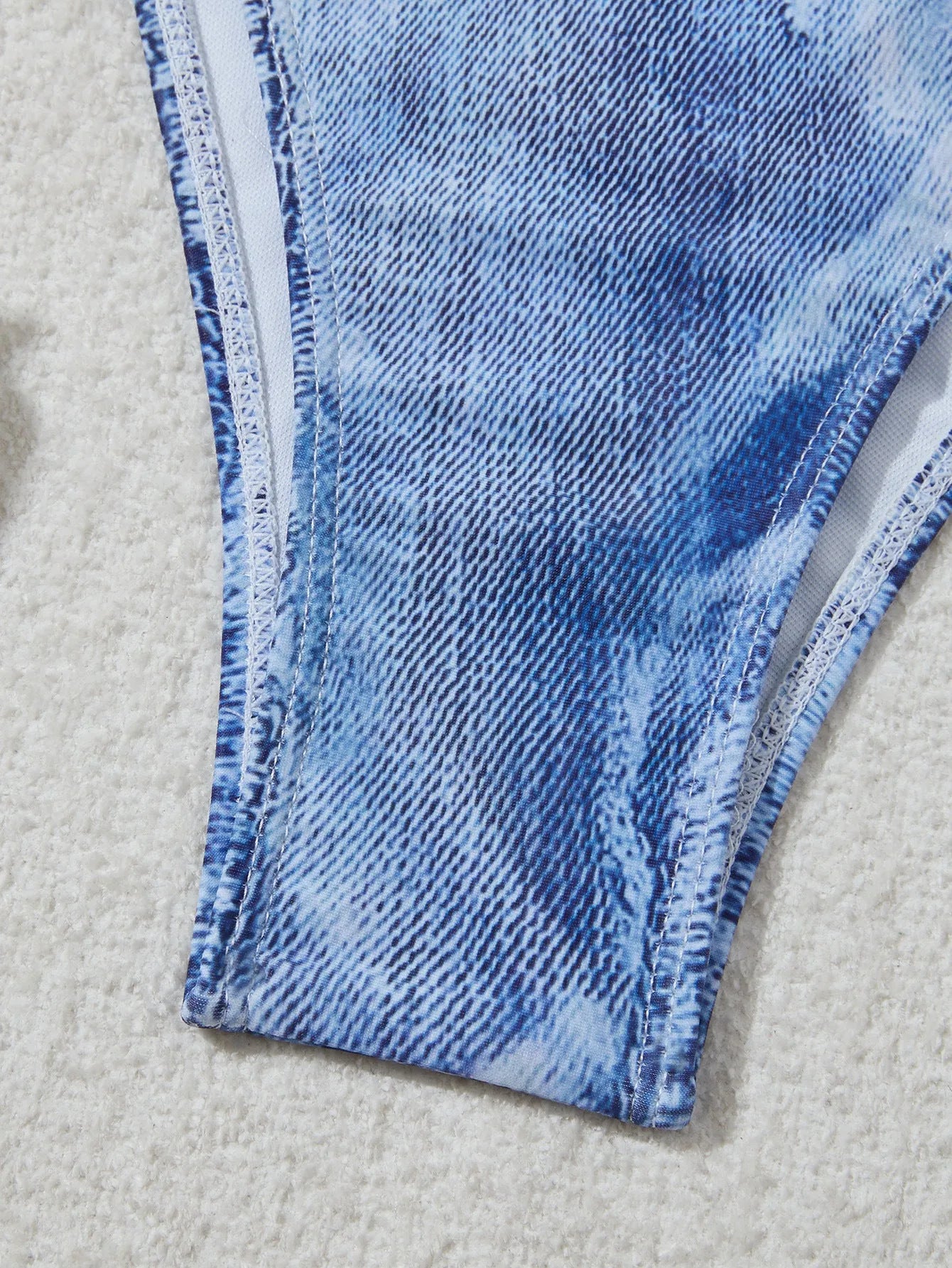 Women's denim blue printed bikini set with adjustable straps on a mannequin.