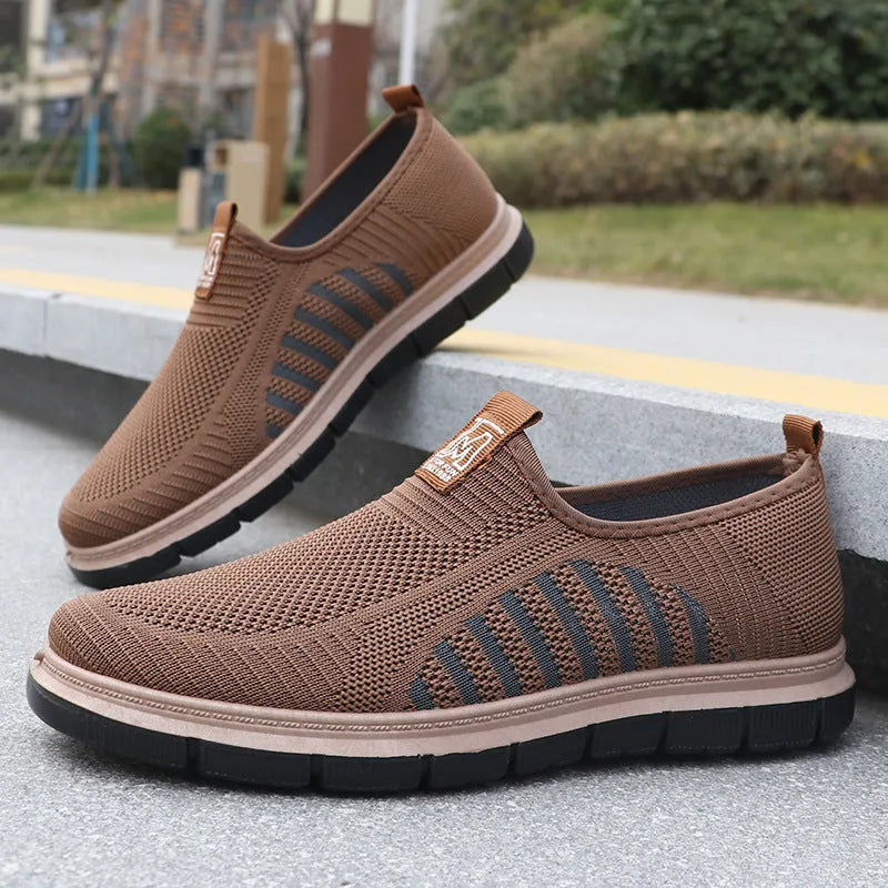 Men's slip-on casual sneakers with black mesh upper, low top, flat heel, and round toe.