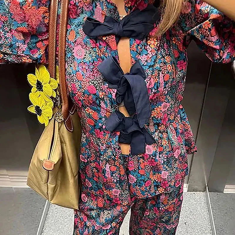 Women's floral print trouser suit with puff sleeves and tie-neck top, coordinating trousers