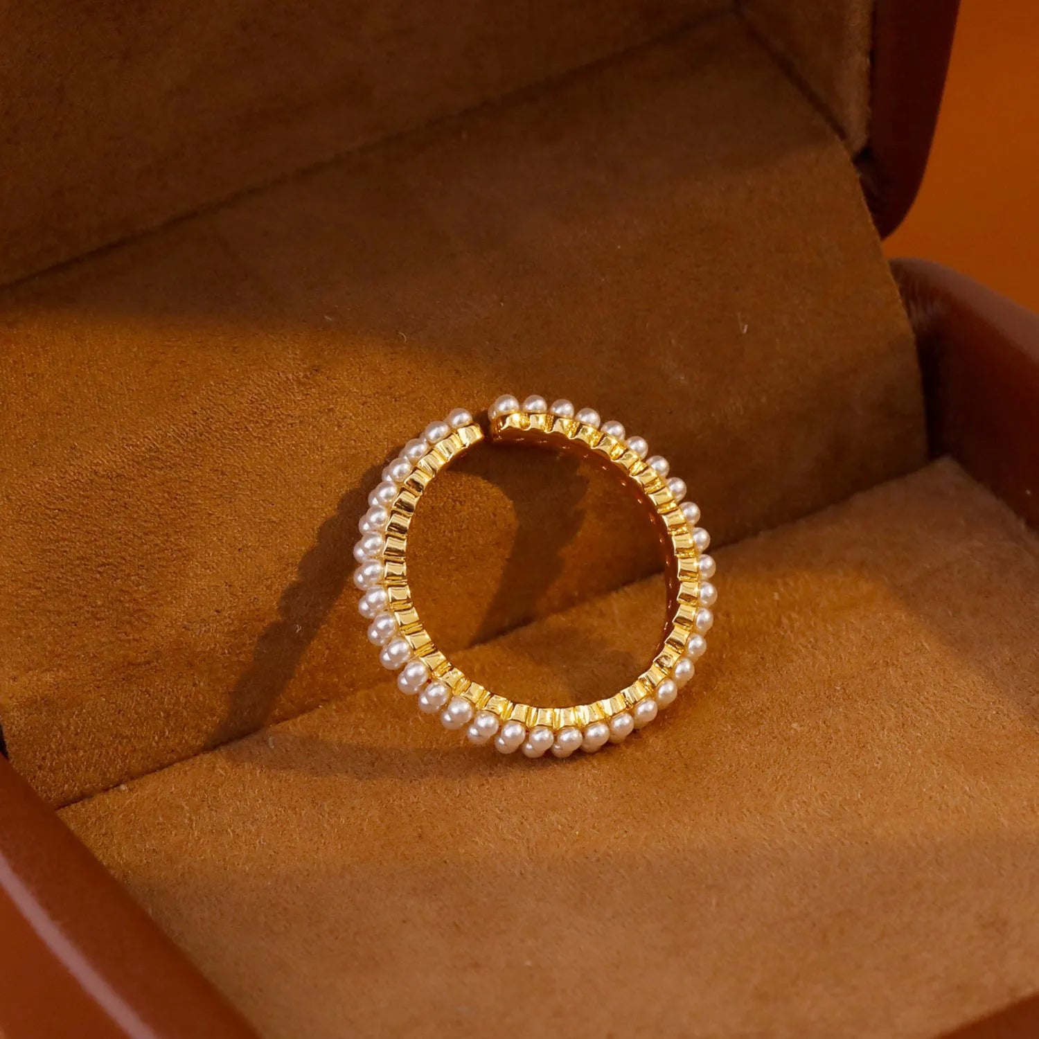 Gold electroplated open mouth pearl ring with geometry design on a copper base.