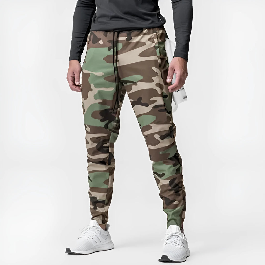 Male model wearing dark grey loose-fit fitness trousers with ankle ties.