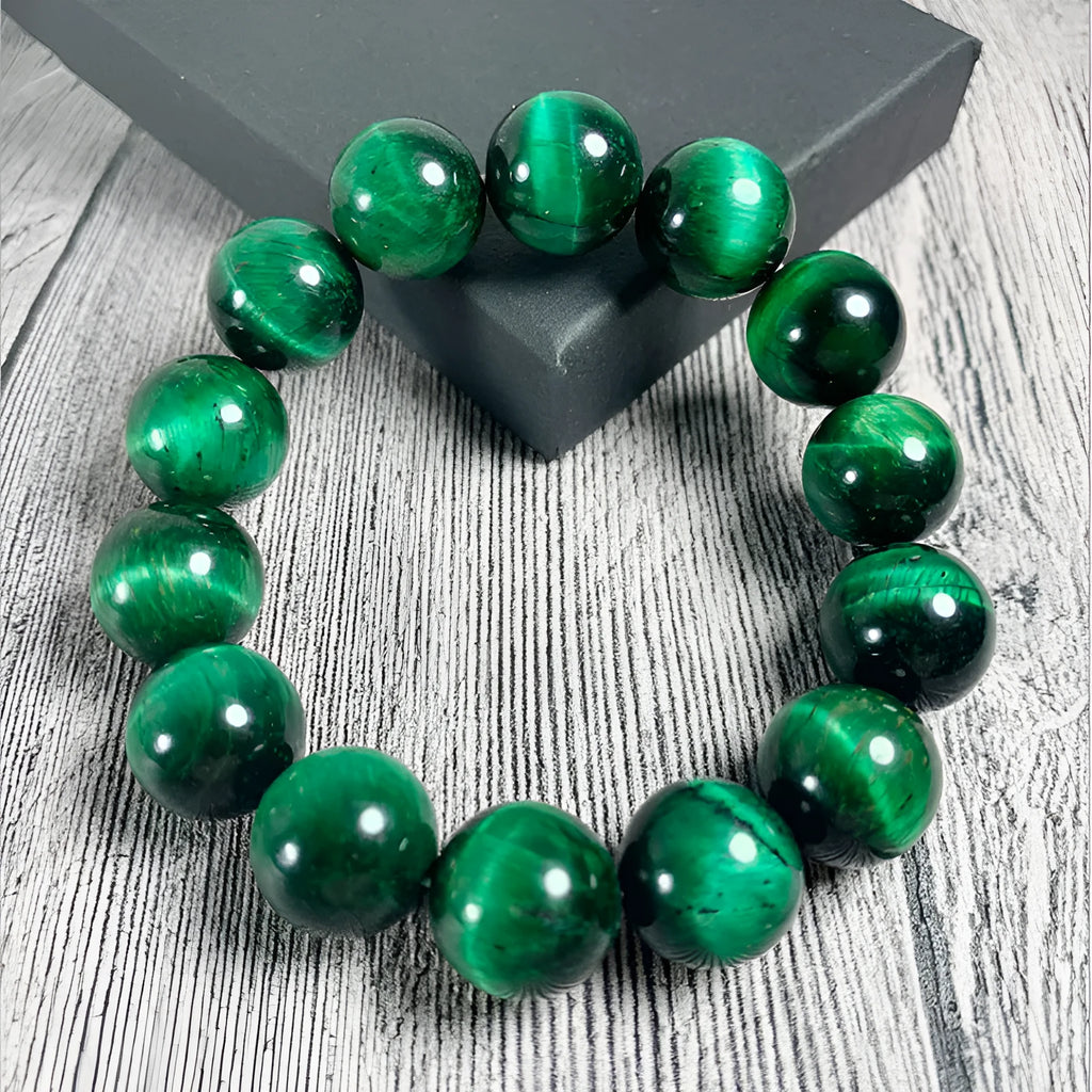 Green Tiger Eye stone bracelet with round polished beads on a wrist.
