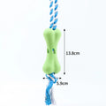 Green porous bone-shaped rope knot dog toy for chewing and holding treats.