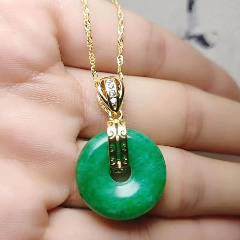 Vacuum electroplated emerald green jade pendant in safety buckle shape on white background