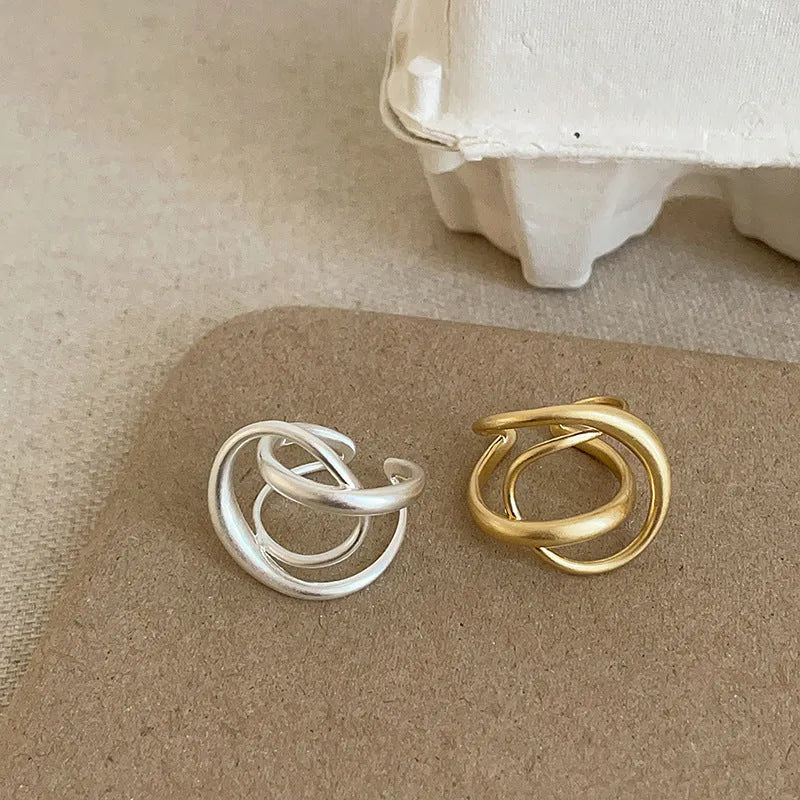 Geometric open ring with interlaced matte metal construction in gold and silver plating options