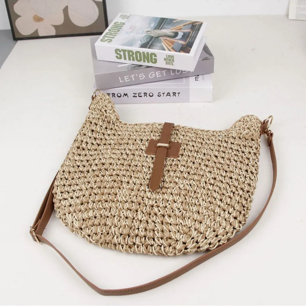 Handmade beige square woven bag with a shoulder strap on a neutral background.