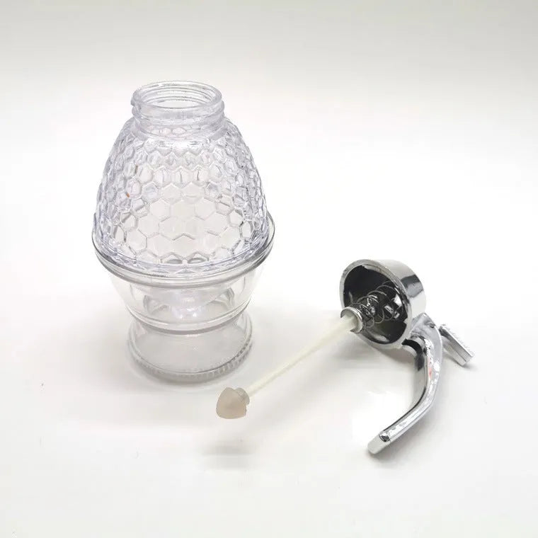 Transparent squeezable honey jar dispenser with 200ml capacity and bee design, sitting on a kitchen counter