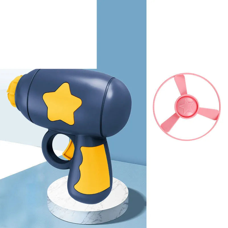 Blue plastic flying saucer launcher toy with LED-lit discs on a yellow target board.