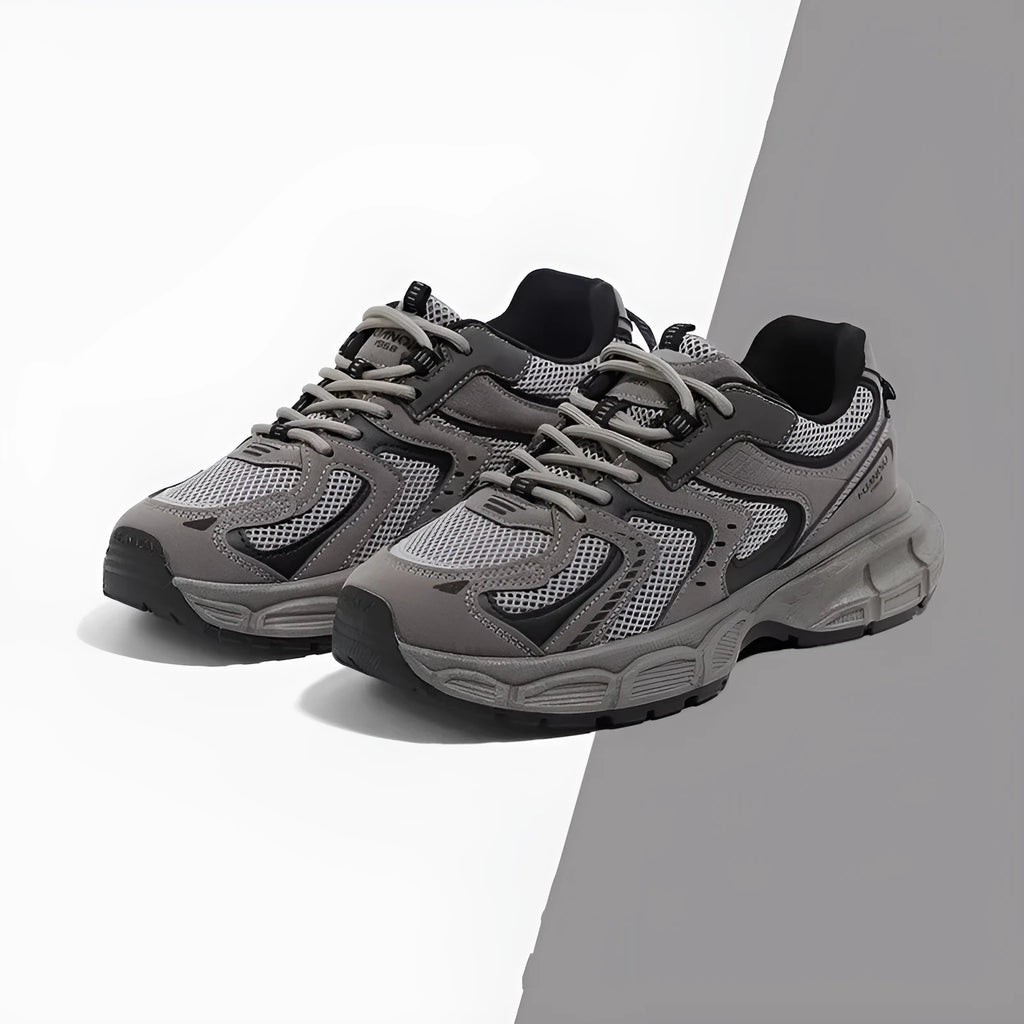 Grey chunky platform sneakers with leather stitching and lace-up design on a white background.