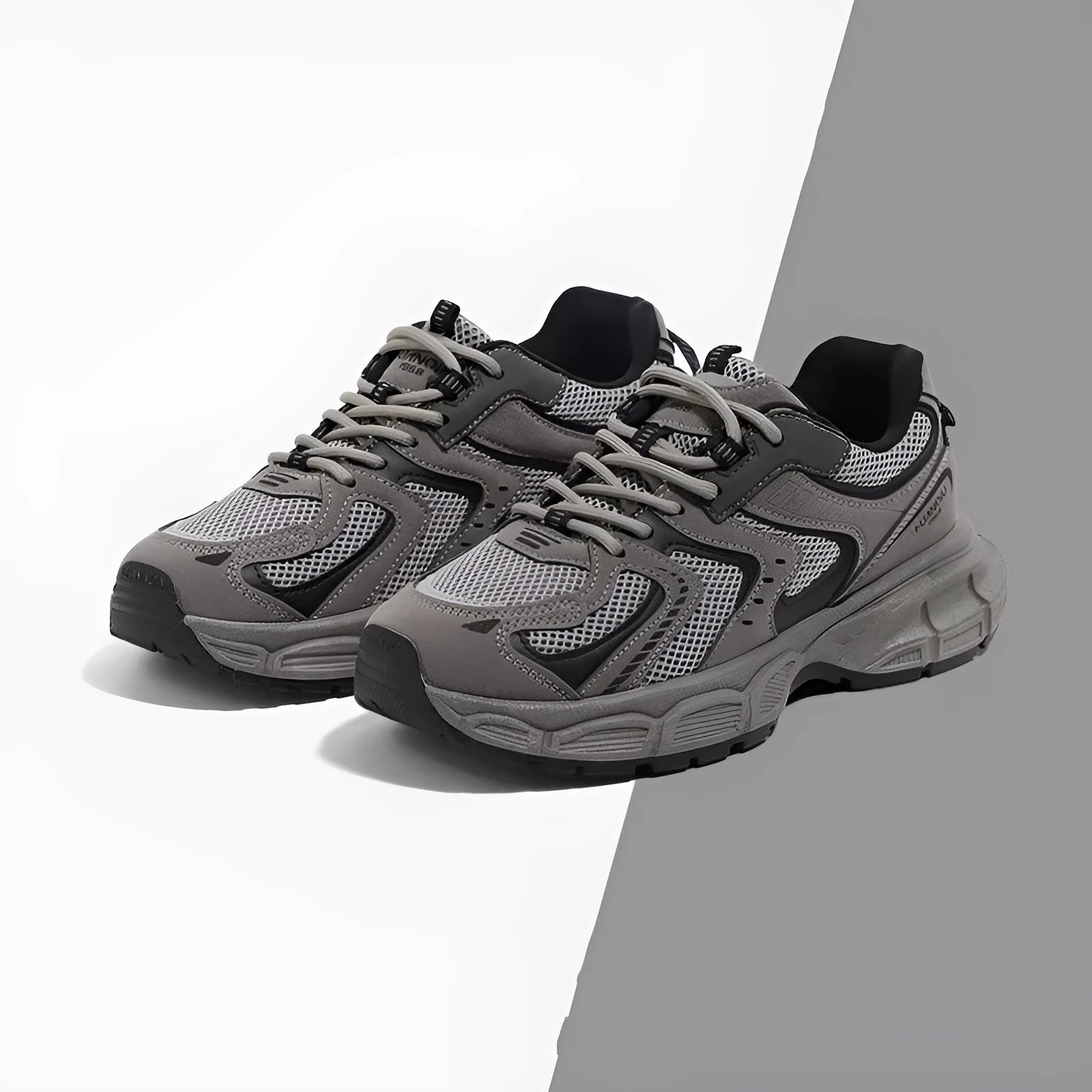 Grey chunky platform sneakers with leather stitching and lace-up design on a white background.