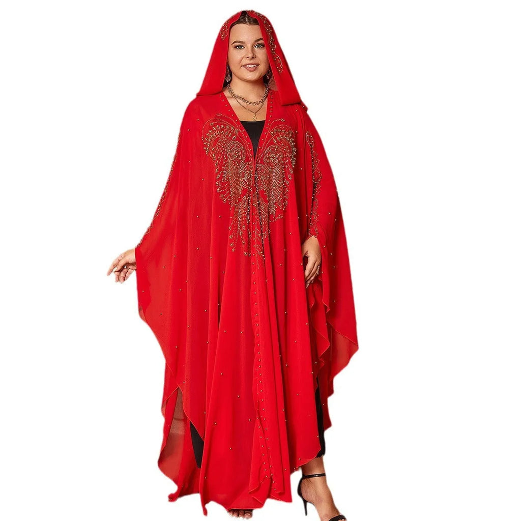 A woman wearing a long purple chiffon cape with rhinestone beading draped over the shoulders.