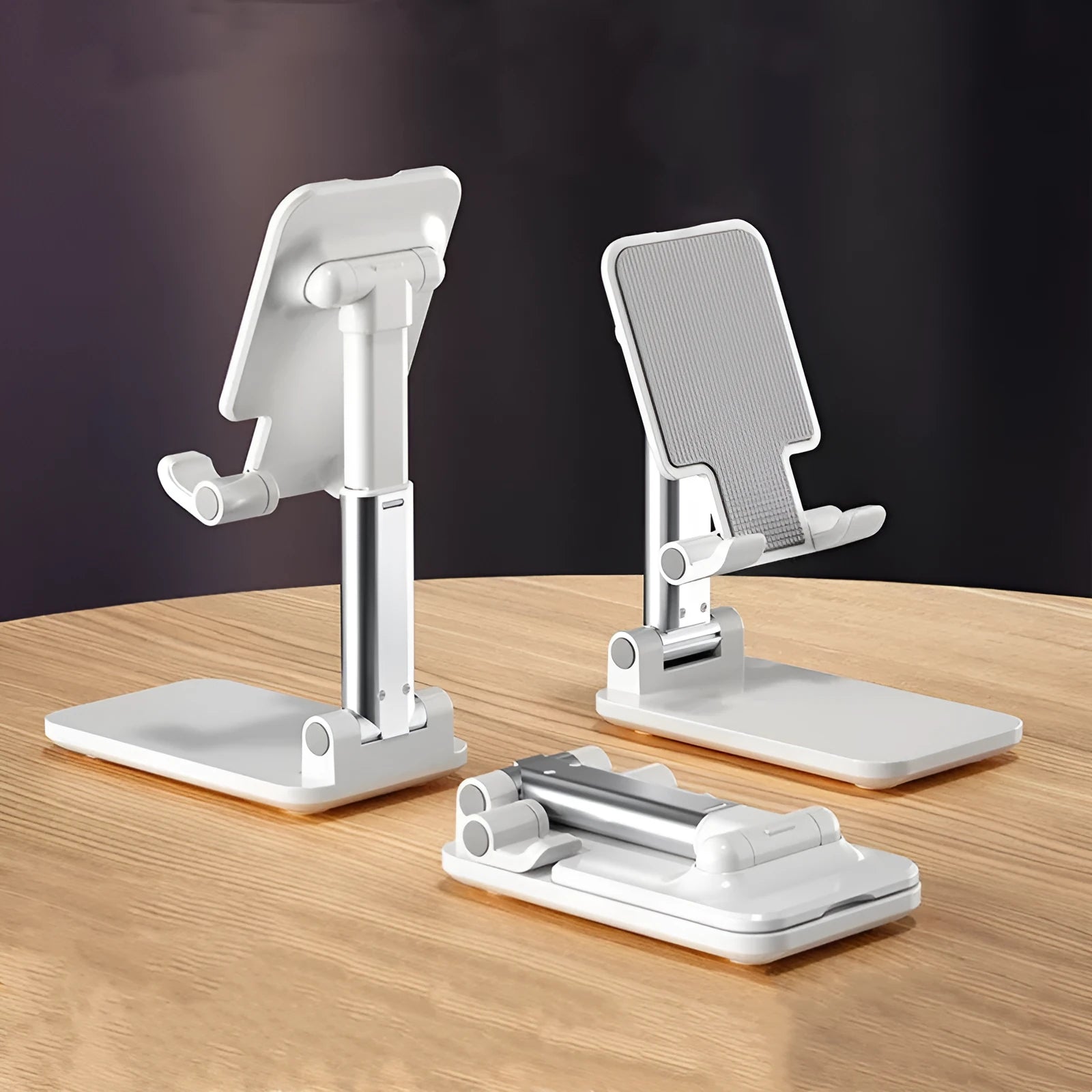 Folding telescopic mobile phone bracket in white, blue, green, or pink colours on a desktop.