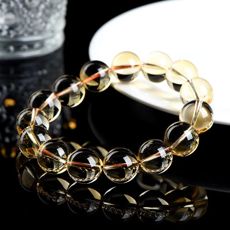 Natural honey-yellow citrine bead bracelet with hand-knotted cord, shown in scattered bead style.