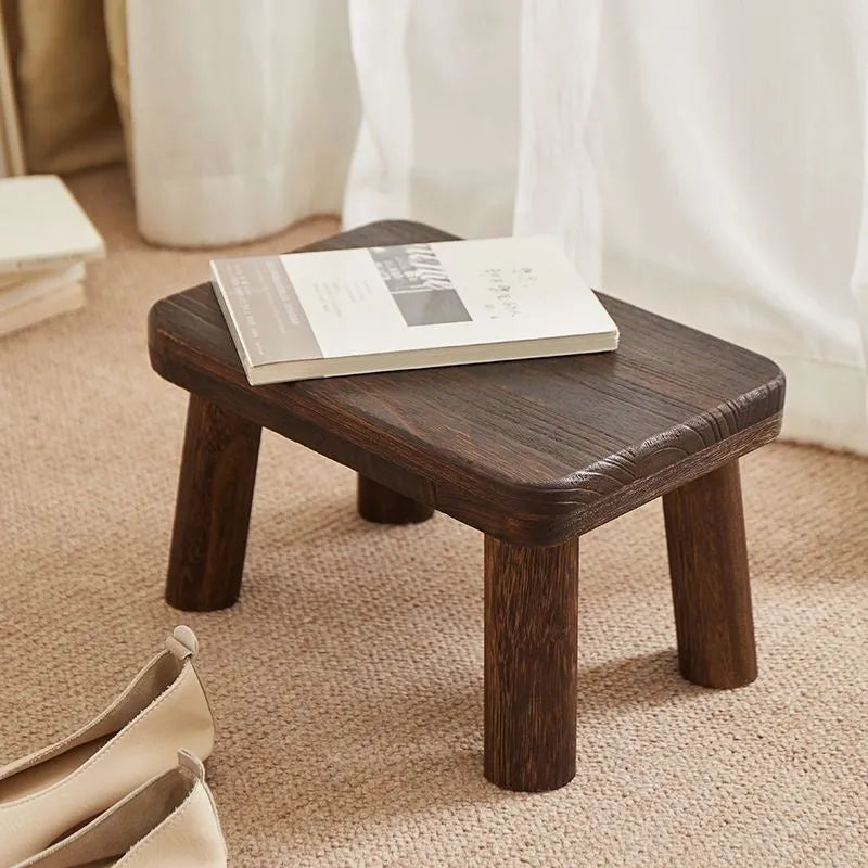 Solid wood household stool with distressed finish, shown as a changing stool or footrest.