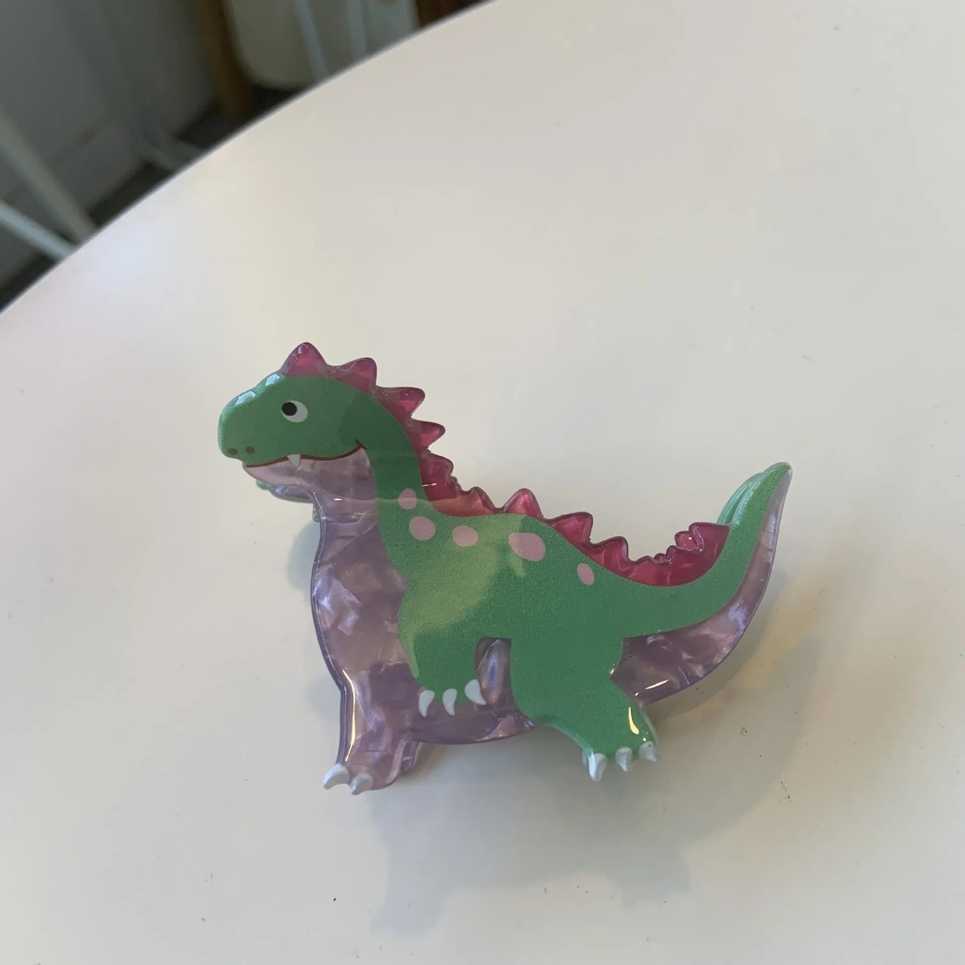 Acrylic dinosaur jaw hair clip showing six colour variations with grip-style fastening mechanism
