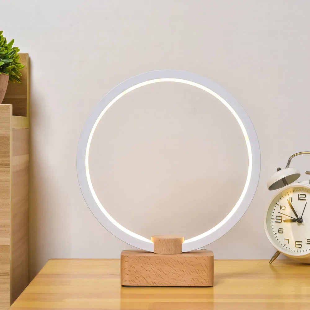 Round small solid wood and bamboo USB-powered LED night lamp on a table.