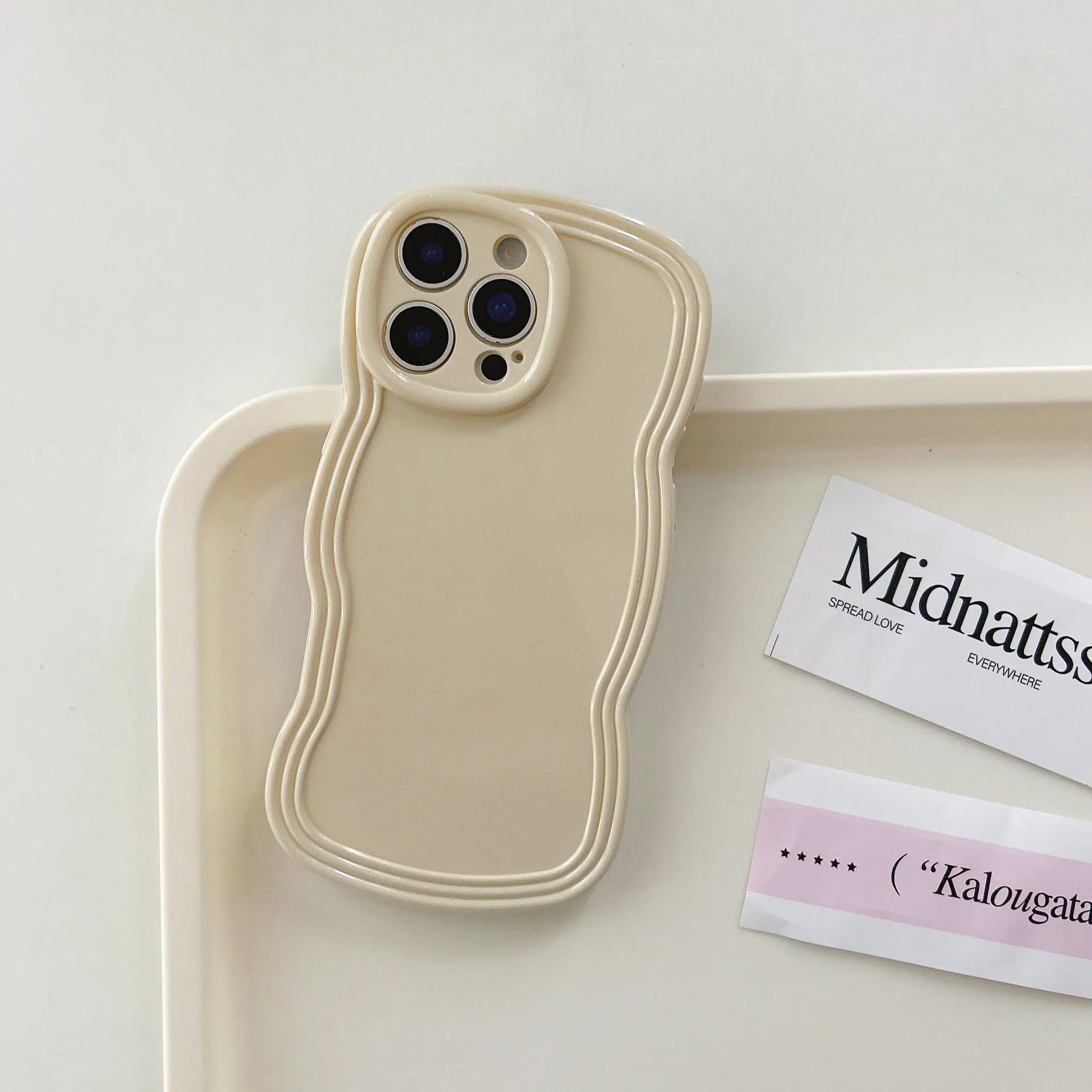 Glossy iPhone case with a soft cream and candy-colour wave pattern on a pink background.