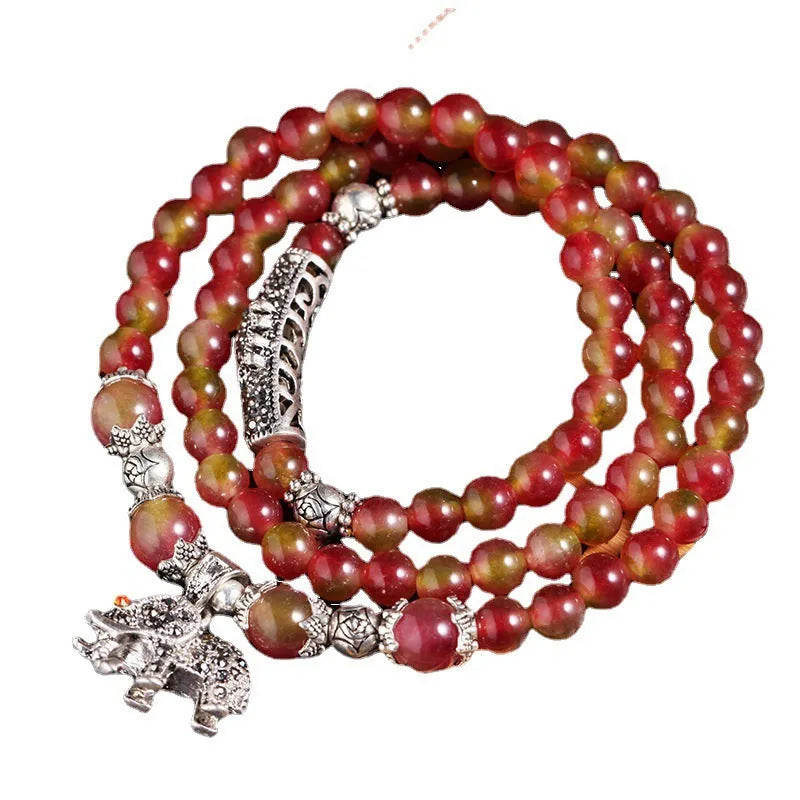 Handcrafted watermelon crystal bracelet with Chinese knot design showing 8mm elephant-style beads