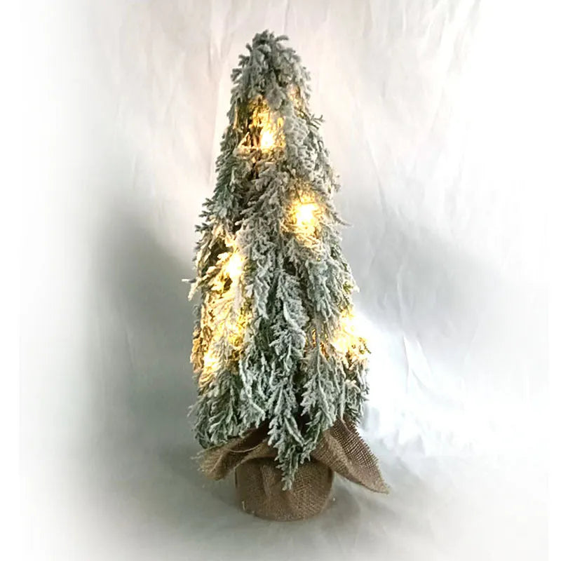 Small 24-inch white artificial Christmas tree with lights and snow spray on a desktop