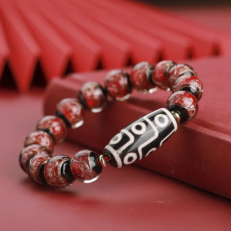 Close-up of a handcrafted coloured glaze bracelet with multi-colour lucky beads and auspicious Chinese patterns.