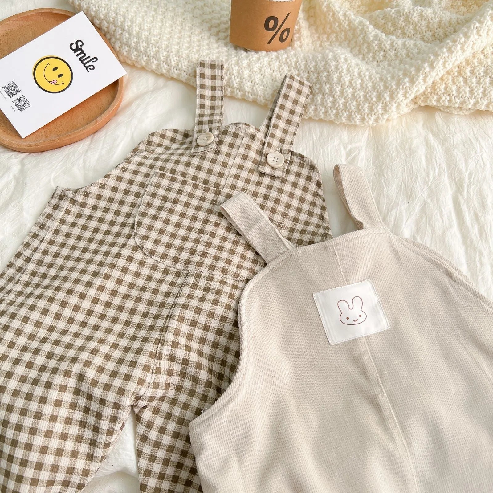Infant cotton corduroy overalls in creamy white with large front pockets and double-breasted closure