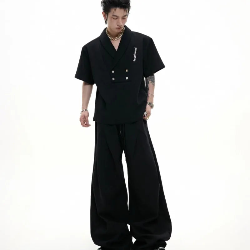 Men's dark grey cotton sports suit with V-neck short-sleeve jacket, padded shoulders, metal embellishments, and matching shorts.