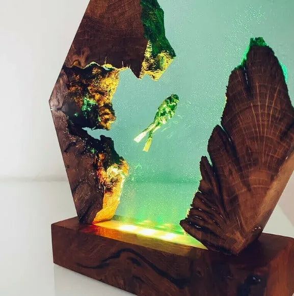 Small transparent resin luminous diver and humpback whale night light with USB plug on shelf