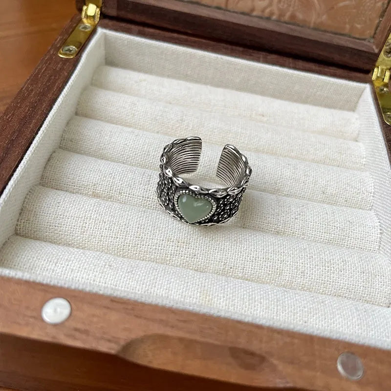Retro-style adjustable silver heart ring shown in white and green colour options.