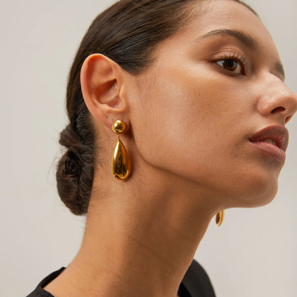 A pair of gold-coloured geometric water drop pendant earrings made from stainless steel.