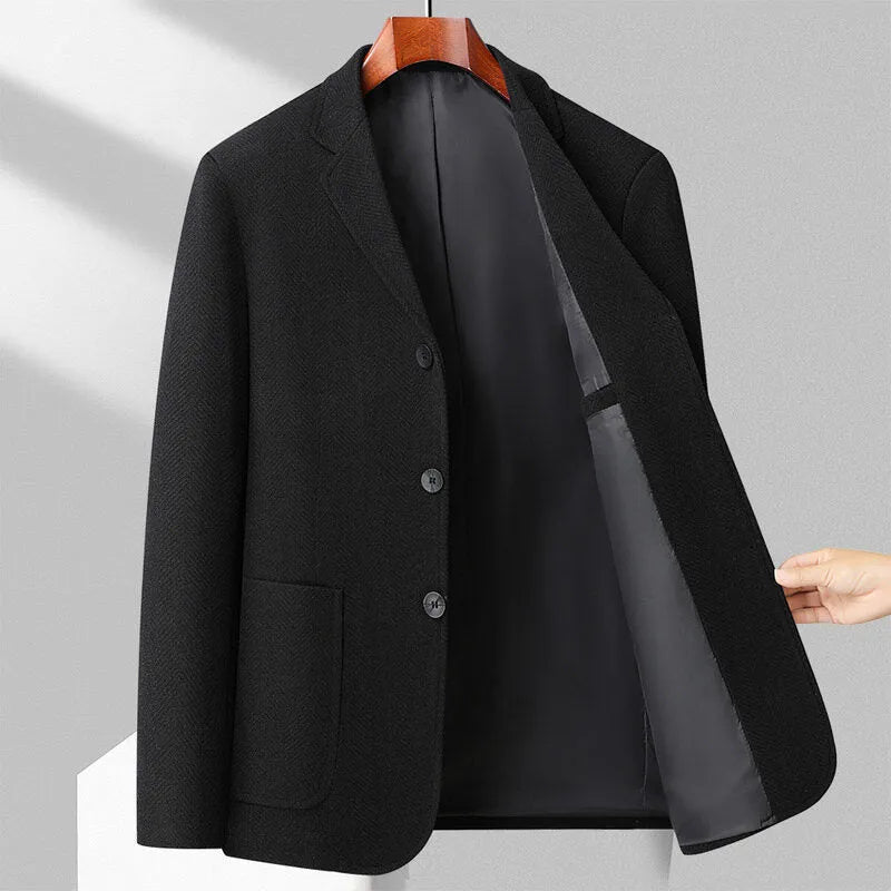 A man wearing a simple, loose-fit solid-colour woolen coat suitable for spring or autumn.