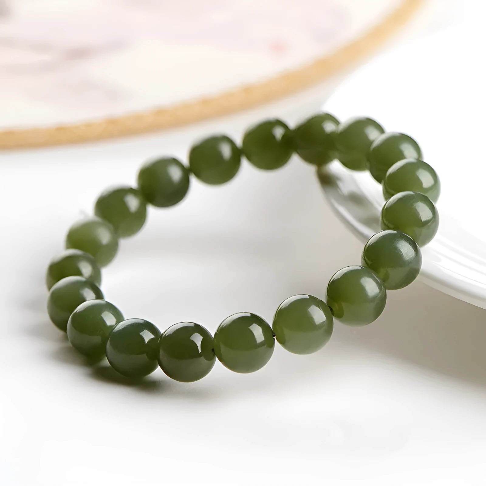 Polished Hetian jade ball bracelet on a wrist, showing spherical beads in a clear, ice-like colour.