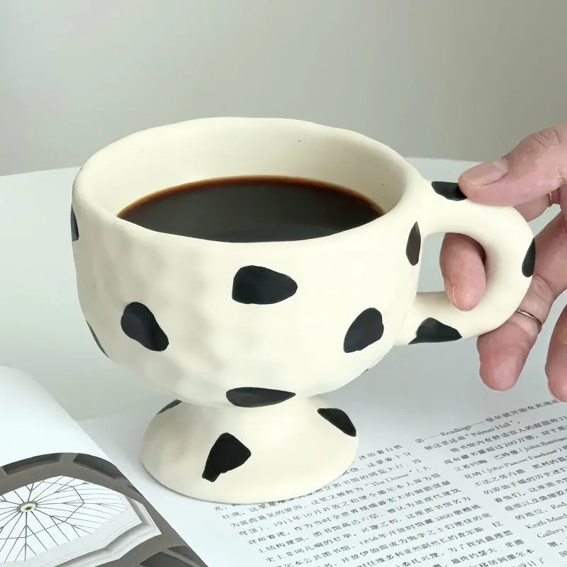 Hand-pinched irregular shaped ceramic mug in a solid colour on a plain background.