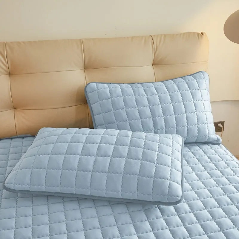 Class A waterproof washed cotton fitted sheet in blue on a bed.