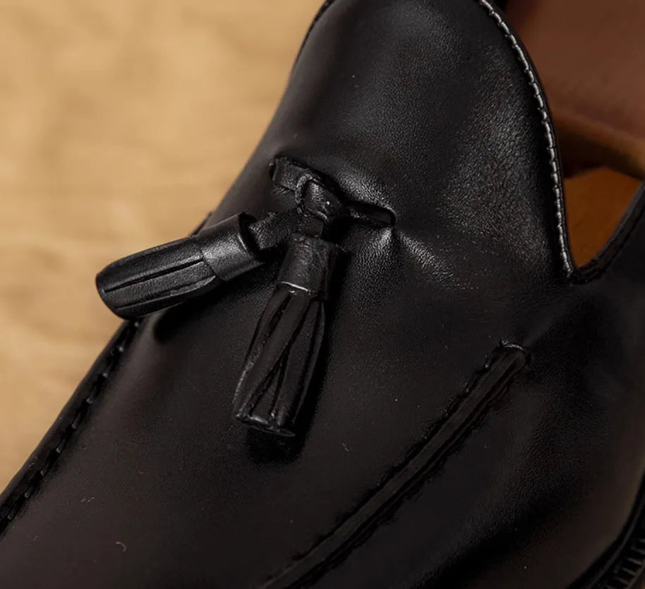 Men's black genuine leather loafers with a fringed detail and slip-on design.