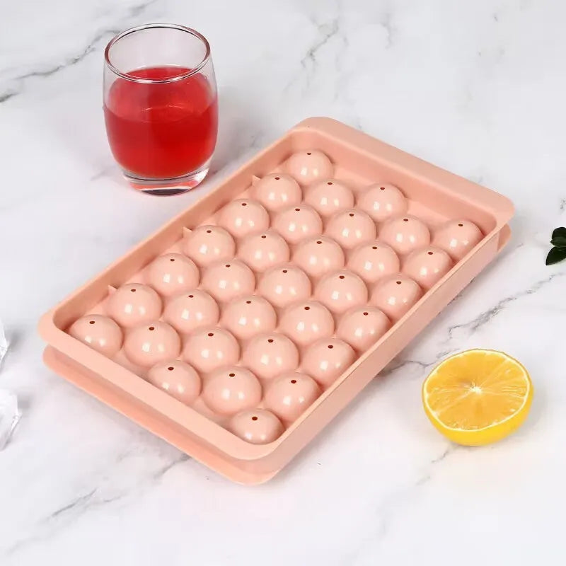 Blue silicone ice cube tray with lid showing 33 round cavities for making ice balls