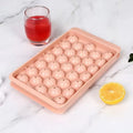 Blue silicone ice cube tray with lid showing 33 round moulds