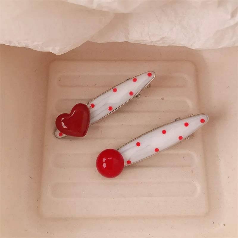 Red stereo love heart-shaped hairpin with French retro dots and willow leaf decoration on a white background.