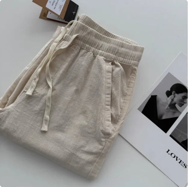 Men's loose-fitting straight-leg casual trousers in beige with an elastic drawstring waistband.