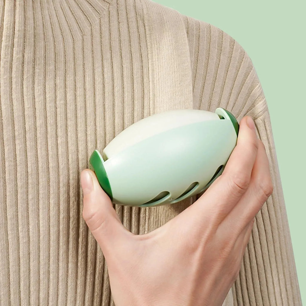 Green washable reusable gel lint roller ball for pet hair removal on fabric.