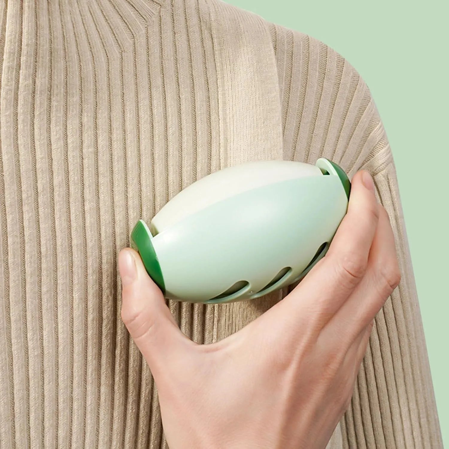 Green washable reusable gel lint roller ball for pet hair removal on fabric.