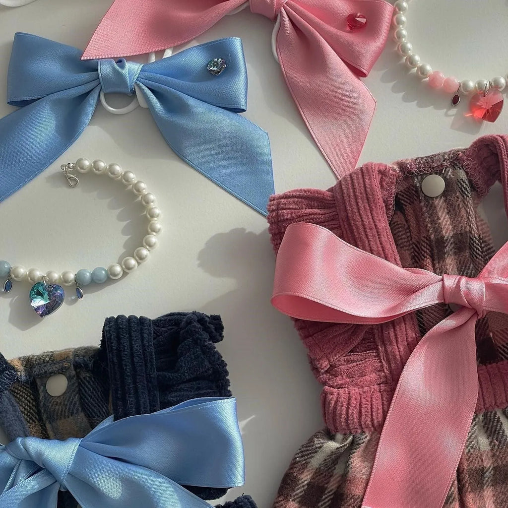 A blue dog hair band with a large princess-style bow and adjustable tension strap on a white background.