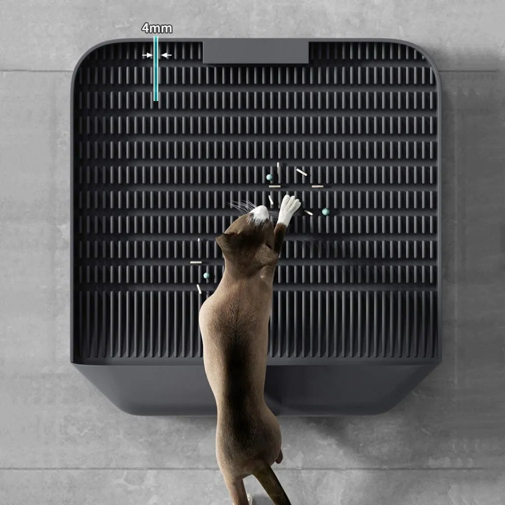 Large black cat litter pedal mat with slanted design next to a litter box.