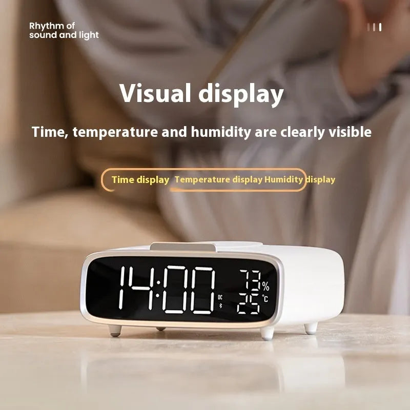 White wireless charger bluetooth speaker with LED night light and alarm clock display on flat surface