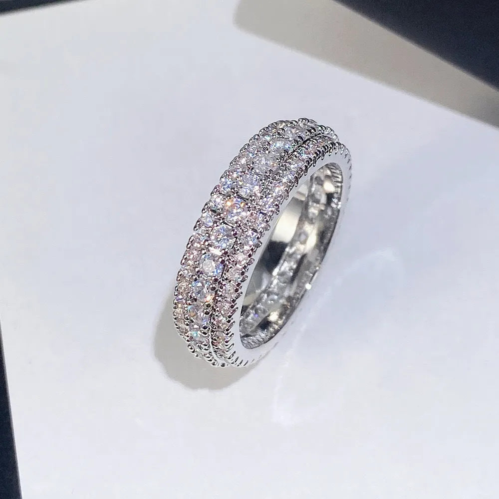 A geometric copper ring with a triangular zircon stone inlay, shown in a white gold colour finish.