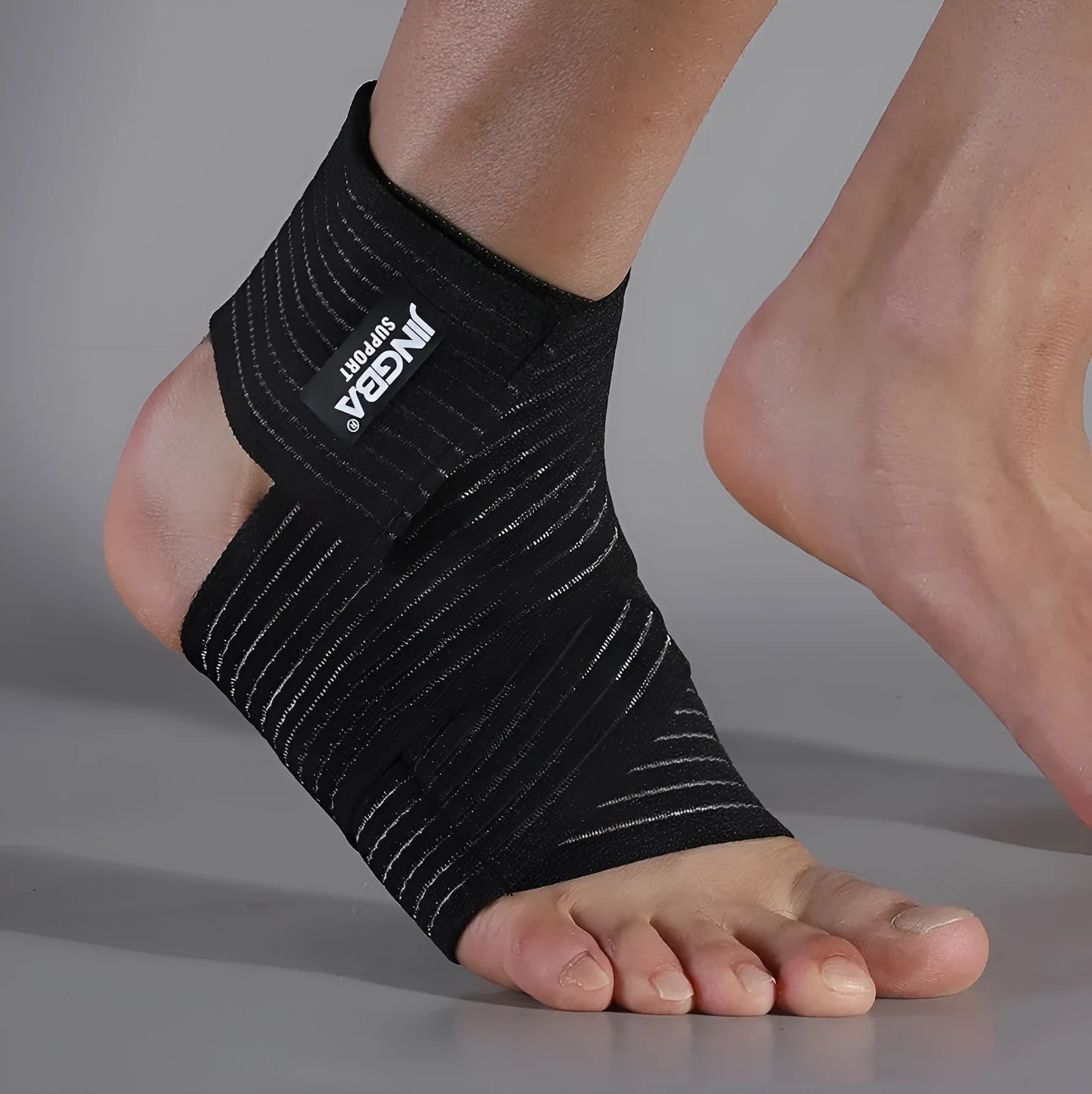 Black adjustable sports ankle support bandage wrapped around a joint